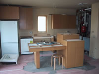 The purpose of the photograph is to show the construction phase of the kitchen in the Milwaukee Idea Home. Several parts of the kitchen reveal open pipes, not fully assembled pieces, and the basic appliances that are used in the kitchen. The viewer is able to see the basic layout of the kitchen and how close it is to completion. The layout is similar to the mock-up that was shown in an earlier picture.